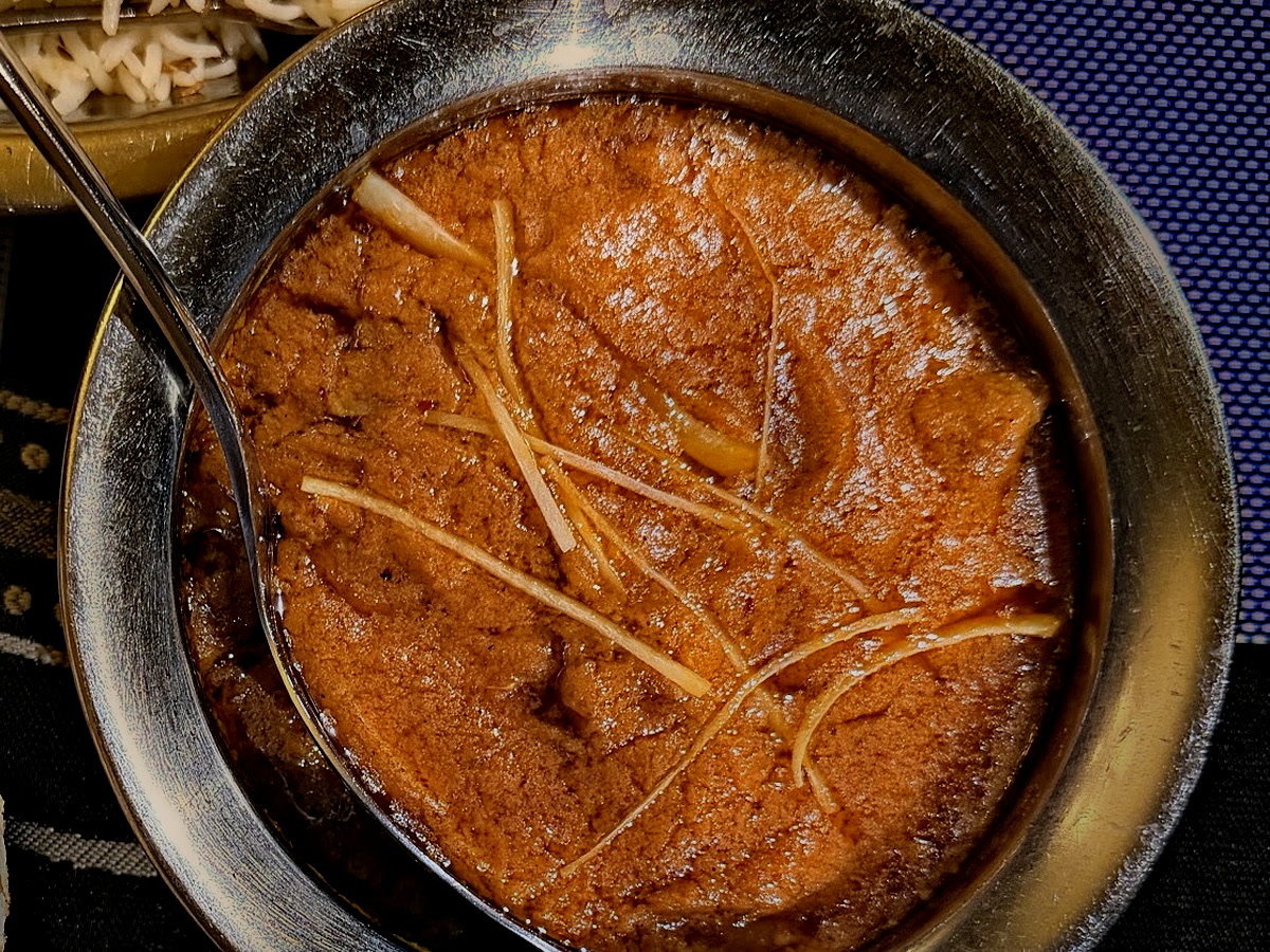 Steel karahi of slow-cooked gravy topped with ginger juliennes